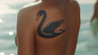 © Earny - A close-up of a tattoo of a swan on a person's shoulder, highlighting intricate details and summer vibes.