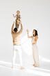 © Sunshine - Father throws his little son up in his arms, and the mother looks at them. Concept of family