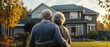 © john - Rear view of Senior couple in front of their new house