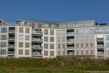 Looking up at Kade Zuid exterior facade of newly build luxury apartment buildings along riverside of river IJssel seen from low waterway. Engineering and urban development real estate concept.