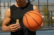 © svetlana_cherruty - Sports man or basketball player eating energy bar. Muscular athlete snacks on protein bar while resting after workout at stadium.