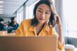 © BullRun - Positive female freelancer downloading media files during distance job with startup project using high speed internet connection on netbook, successful student preparing course work presentation