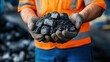© Sittipol  - A miner holding a lump of raw coal, ready for transportation and processing