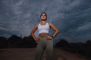 Sport woman portrait at the overcast cloudy day dramatic view