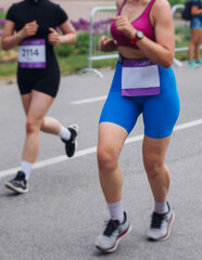 Wall Mural - Marathon runners crowd, sportsmen participants start running the half-marathon in the city streets, crowd of sportswomen joggers in motion, group athletes outdoor training competition in a summer day