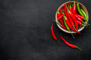 Wall Mural - Cooking hot food with chilli pepper on black table background top view copy space