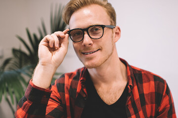 Confident guy adjusting glasses