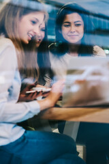 Wall Mural - Prosperous young women smiling during watching motivation webinar using 4g wireless internet on laptop computer, happy successful female friends reading received email via application on netbook