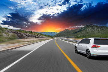 Wall Mural - The car is driving along the highway surrounded by picturesque nature.