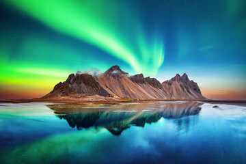 Wall Mural - aurora borealis northern lights over famous stokksnes mountains on vestrahorn cape. reflection in th