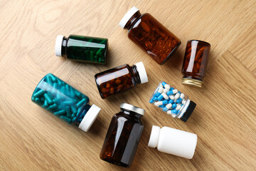 Wall Mural - Pharmacist. Different pills in plastic bottles on wooden table, flat lay