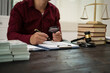 © NanSan - A male lawyer is working at his desk on an online judicial review, focusing on justice, fairness, and legal compliance.He reviews cases, contracts, and legal matters based on general law principles