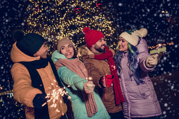 Canvas Print - Photo of positive good mood four buddies wear windbreakers firing xmas bengal fires together outside urban market park