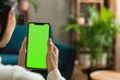 © CogniLens - Application mockup indian woman in her 40s holding an smartphone with an entirely green screen