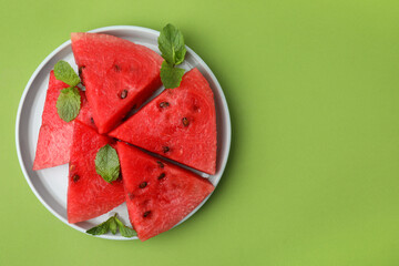 Sticker - Pieces of tasty watermelon and mint on green table, top view. Space for text