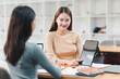 © PRIME STOCK LAB - Collaborative discussion between two women in modern workspace, showcasing engagement and teamwork. atmosphere is productive and focused, highlighting use of technology.