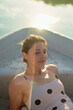© Connect Images - Young woman enjoying a peaceful moment on a boat during a sunny day.