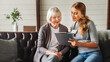 © InsideCreativeHouse - Front view shot of caring young woman nurse help old granny during homecare medical visit while making notes in clipboard. People healthcare concept