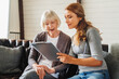 © InsideCreativeHouse - Senior old woman sits with middle aged nurse making notes at retirement house