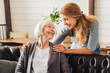 © InsideCreativeHouse - Middle aged nurse taking care of old woman indoors
