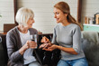 © InsideCreativeHouse - Senior woman taking pills from her daughter while holding glass with water.