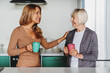 © InsideCreativeHouse - Senior woman enjoying in meeeting with her daughter. They in the kitchen drinking tea or coffee together
