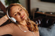© InsideCreativeHouse - Close up of modern middle aged female in headphones listening favorite track and enjoying
