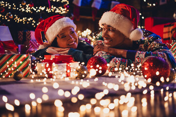 Canvas Print - Photo of two young peaceful partners look each other giftbox tree toys festive christmas illumination apartment indoors