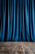 © ASGraphicsB24 - Dark blue theater curtains hang over a wooden floor.