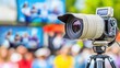 © Suphawan - A digital video camera capturing live footage of a concert, with stage lights and a crowd in the background.