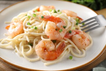 Delicious pasta with shrimps and green onions on table, closeup