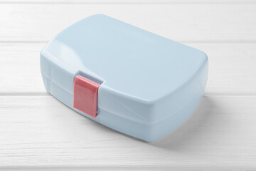 Light blue lunch box on white wooden table