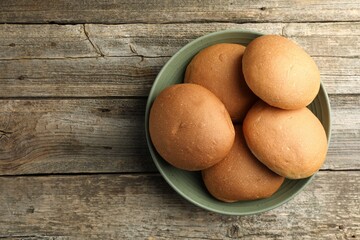 Wall Mural - Fresh tasty buns on wooden table, top view. Space for text