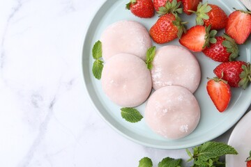 Canvas Print - Delicious mochi with strawberries and mint on white marble table, top view. Space for text