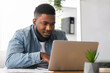 © Prostock-studio - Portrait of millennial african american businessman working on laptop in modern office, closeup