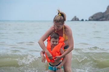 mom teaches her son to swim in sea