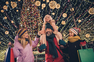 Wall Mural - Portrait of attractive cheerful adorable family spending weekend buying gifts things having fun festal time strolling city urban outdoors