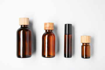 Poster - Essential oils in bottles on light background, flat lay