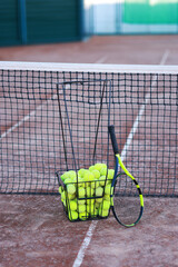 Wall Mural - Tennis racket and balls in metal basket on court