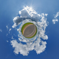 simple little tiny planet without buildings in blue sky with beautiful clouds. Transformation of spherical panorama 360 degrees. Spherical abstract aerial view. Curvature of space.