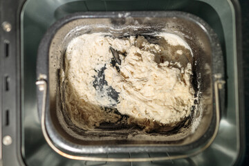 A bowl of flour sits in a bread maker