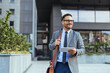 © Dragana Gordic - Confident Businessman Walking Outside Office Building With Tablet
