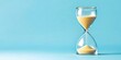 © Monirknn - an hourglass filled with sand flowing steadily. isolated on blue background with copy space. tracking time concept, generative ai