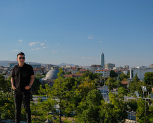 Portrait of young handsome man in front of city landscape