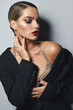 © EkaterinaJurkova - Portrait of a beautiful young girl with bright evening make-up and a smooth hairstyle. The girl is dressed in fashionable clothes - a black jacket and a bra made of crystals.