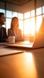 © BoOm - Business meeting with laptop, coffee cup, and sunlight streaming in from windows.
