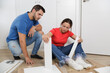 © Lucia PSV - Young couple just married assembling a piece of furniture in their home. With screwdriver and tools in hand to follow the instruction book. Handyman couple. They are the owner.New house, new furniture
