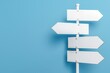 © panumas - A white sign with four arrows pointing in different directions. The sign is on a blue background. The sign is meant to be a symbol of guidance or direction