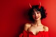 © Riya - Smiling woman with devil horns in red dress