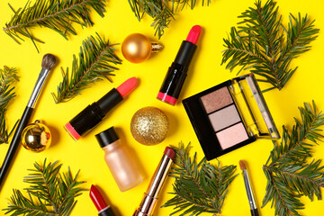 Wall Mural - Flat lay composition with makeup products and Christmas decor on yellow background